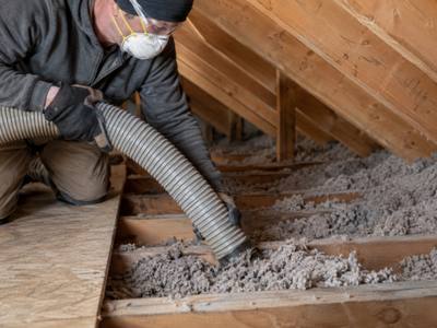 Removal hose vacuuming loose fill from between attic joists