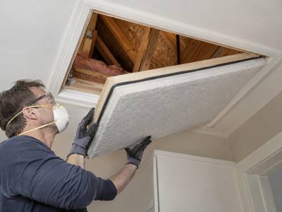 Insulated attic hatch cover being fitted from below in an Innisfil home